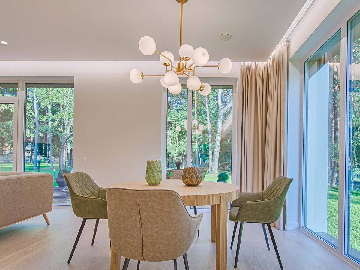 dining area of table and four chairs under large hanging chandelier