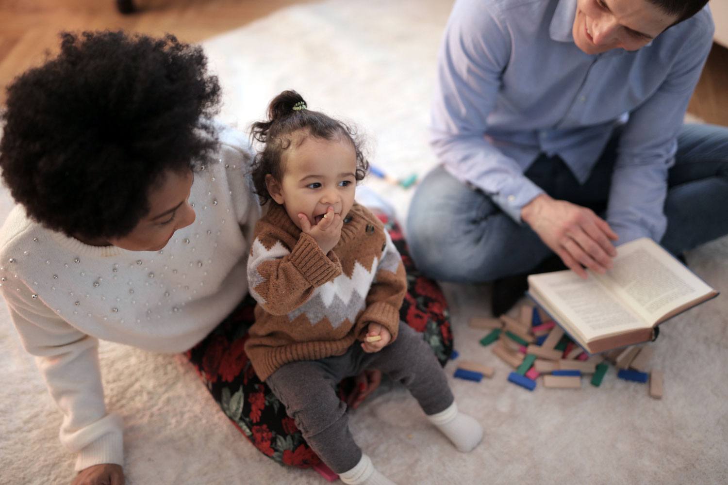 young parents play with toddler daughter