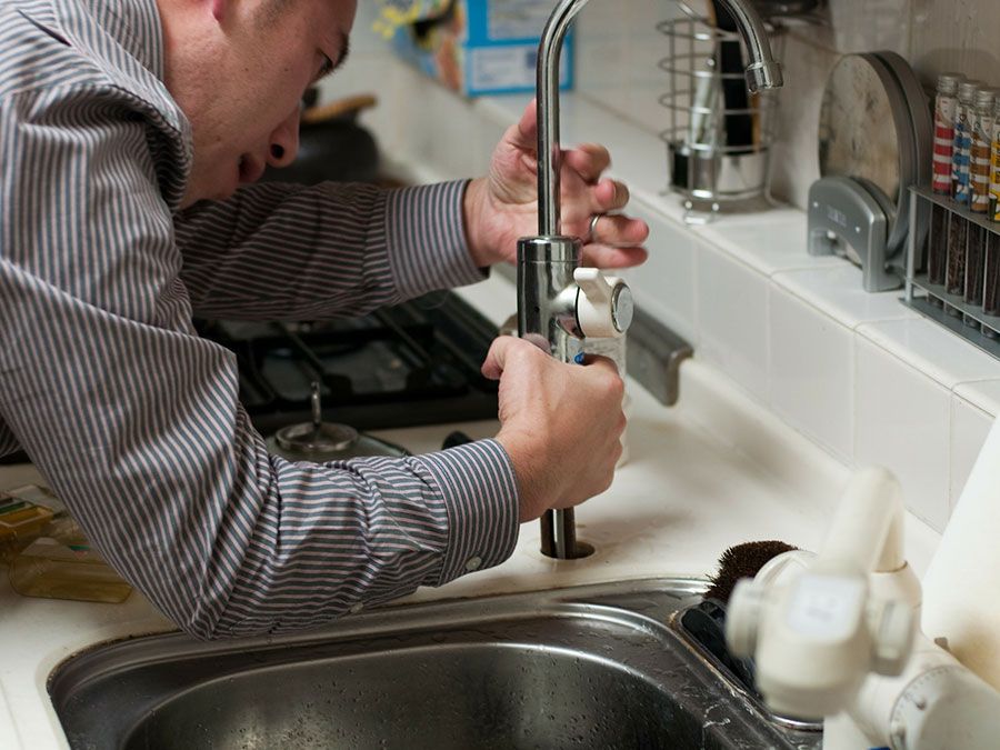 plumber working on kitchen sink installation